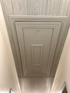 an overhead view of a hallway with white walls and wood paneling on the ceiling