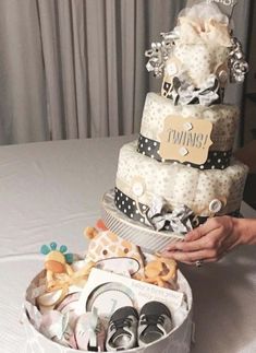 a cake that is sitting on top of a table with baby shoes in the middle