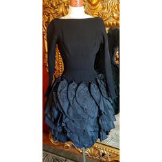 This is an amazing dress!  Very high quality. The top of the dress is made of soft black wool.  Princess seaming for a tight fit. At the top of hip starts rows and rows of ruffled black taffeta.  This is attached to very heavy interfacing.  It is a pencil fit underneath.  There is only one area on one of the ruffles that has some marks three very tiny holes. I believe the marks will lighten up or possible dissapear with some care.  I am going to try to work on it.  Right now it is sold as is.  Aside from that this dress is in amazing shape.  Center back metal zipper.  And two of the ruffles below the back of the waist attach with snaps so you can get into the dress.  This is dress would best fit an XS but please note the measurements for a proper fit.  All sales are final. Measurements Arm Fitted Dress For Fall Vintage Events, Fitted Dresses For Fall Vintage Events, Vintage Fitted Dress With Ruffled Skirt, Fitted Vintage Dress With Ruffled Skirt, Fitted Black Dress For Vintage Events, Black Fitted Dress For Vintage Events, Vintage Black Ruffled Dress, Vintage Black Dress With Ruffles, Fitted Ruffled Dress For Vintage Events