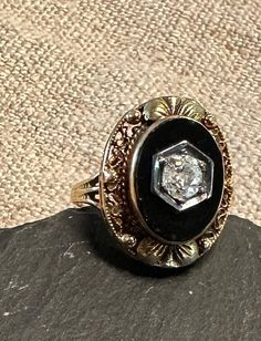 "10K antique Edwardian ring old European cut Dia(approx. 1/4 Carat), black onyx.  Size 4 3/4, wt.-  3.4 grams, top of ring approx. 3/4\" by 1/2\".  Condition very good for its age, any slight wear commensurate with age-photos show details.  Elegant black and white, onyx raised bezel set, white antique diamond set in white gold the ring is yellow gold, Combination of flattering oval shape, filigree added leaf decoration make for an intriguing design." Black Heirloom Ring With Center Stone, Heirloom Black Ring With Center Stone, Black Oval Diamond Cut Rings, Black Filigree Ring For Formal Occasions, Black Engraved Gemstone Ring For Anniversary, Formal Black Filigree Ring, Black Gemstone Engraved Ring For Anniversary, Victorian Black Oval Rings, Heirloom Black Diamond Ring With Rose Cut Diamonds