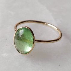 ITEM DESCRIPTION: >> The Ring is made from Solid 14K Yellow Gold. Gemstone used is absolutely natural and ethically sourced. >> Natural deep green emerald coloured garnet popularly known as Tsavorite is studded on it with utmost precision. >> This is a minimalist design which makes it a hassle free and everyday jewelry. Gem: Tsavorite Gem size: 7x9 mm Gem weight: Gemstone option 1 : 3.90 carats Gemstone option 2 : 2.69 carats Gemstone option 3 : 3.10 carats Gemstone option 4 : Classic Green Tourmaline Jewelry, Green Stackable 14k Gold Jewelry, Stackable Green 14k Gold Jewelry, Green Tsavorite Rings With Bezel Setting, 14k Gold Green Ring With Polished Finish, Yellow Gold Tsavorite Ring, Gold Tourmaline Ring For May Birthstone, 14k Gold Oval Cabochon Emerald Ring Gift, Green Oval Cabochon Birthstone Jewelry