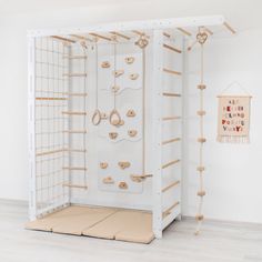 a white room with wooden pegs on the wall and an art piece hanging from the ceiling