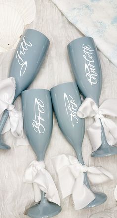 four blue wine glasses with white bows on them