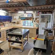 a workbench in a garage with lots of tools on the table and shelves