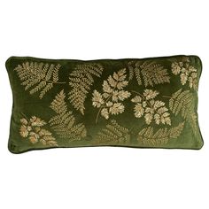 a green velvet pillow with gold embroidered leaves on the front and back, sitting on a white background