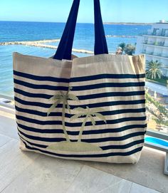 a bag sitting on top of a window sill next to the ocean and beach