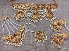 This is a gorgeous semi bridal jadau necklace made with the highest quality gold plating and comes as a full set with jhumar/passa, tikka and choker necklace. The set is very versatile and can also be worn separately.  This lightweight and elegant necklace is perfect for any bridesmaid, bride, sangeet or any occasion or event as a gift for any occasion as any one who loves jewelry will love this statement piece. It has beautiful colors that really make the set a statement piece. Product Details: * Necklace - Comes with adjustable string * Earrings  * Tikka  * Passa  This set is a preorder and will take 2-3 weeks to arrive but reach out to me in case you need it earlier!  This is the actual product picture so no surprises (please note colors may vary slightly due to image resolution etc)  T Jadau Necklace, Punjabi Jewelry, String Earrings, Bridal Jewelry Set, Elegant Necklace, Pakistani Bridal, Elegant Necklaces, Wedding Jewellery, Wedding Jewelry Sets