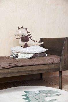 a stuffed animal sitting on top of a wooden bed