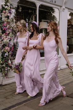 two women in pink dresses walking down the street