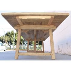 a wooden table sitting on top of a sidewalk