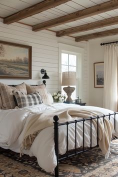 a bedroom with white walls and wood beams