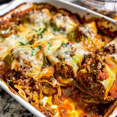 a casserole dish with meat, cheese and vegetables in it on a table