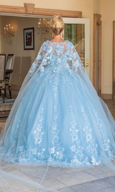 a woman in a blue wedding dress is standing on the floor with her back to the camera