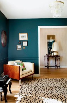 a living room with green walls and leopard print rugs on the hardwood flooring