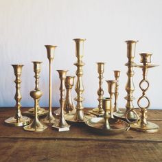 a group of brass candlesticks sitting on top of a wooden table