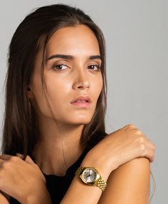 A classic design, elevated. The bold and urban Vivid watch features a statement round face with chunky outer casing that’s juxtaposed by the delicate sunray dial, minimalist numerals and crystal detailing. In elegant yet eccentric gold, silver and white with a 32mm face, Vivid is a powerful piece pairing androgynous design with robust links made of gold-plated stainless steel for effortless sophistication. Chic Gold Everyday Watch, Chic Everyday Gold Watches, Minimalist Gold Watches For Work, Minimalist Gold Watches Suitable For Work, Chic Gold Watches For Work, Chic Gold Watch With Metal Dial, Gold Analog Watch For Workwear, Gold Analog Display Watch For Work, Gold Watch With Analog Display For Work