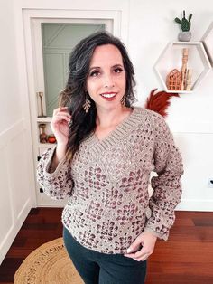 a woman standing in front of a mirror wearing a sweater and leggings with her hands on her hips