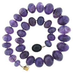 This magnificent vintage strand necklace was neatly strung with 32 natural genuine amethyst in which graduate from 15.6mm to 26mm in diameter throughout. Each of these rondelle shaped stones have a nice polished finish and display an absolutely gorgeous medium purple color, bringing a bold and absolutely incredible look around the neck. This heavy and substantial piece closes with a large, sturdy, push clasp that is crafted from solid 14k yellow gold and is neatly bezel set with a large oval cab Luxury Purple Necklace With Gemstone Beads, Formal Amethyst Gemstone Bead Necklace, Multi Strand Pearl Necklace, Three Strand Necklace, Jade Bead Necklace, Miriam Haskell Jewelry, Artisan Bracelets, Deep Purple Color, Double Strand Necklace