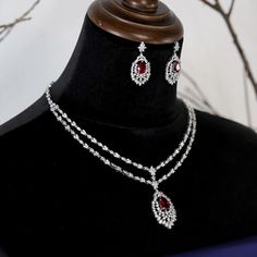 Glamourous and exquisitely elegant 14k white gold plated ruby red and Crystal wedding necklace set, elegant V drop design Perfect for that elegant evening, weddings, and any other special occasion. Every piece is made to perfection, we only use the finest CZ diamond like cubic zirconia for that dazzling and dramatic look and always at a fraction of the price of any bridal boutique. Measures approximately 16"L - fold-over and locked clasp 1 1/2" drop pierced back earring 14K White gold electropla Red Diamond Necklace For Evening, Red Diamond Necklaces For Evening, Dazzling Lab-created Ruby Jewelry For Wedding, Dazzling Lab-created Ruby Wedding Jewelry, Red Diamond Accented Jewelry For Evening, Fine Jewelry Lab-created Ruby Necklaces For Wedding, Red Diamond Jewelry For Evening, Fine Jewelry Wedding Necklace With Lab-created Ruby, Fine Jewelry Lab-created Ruby Necklace For Wedding