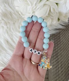 "Personalized blue heeler charm bracelet perfect for any Bluey lover! Double strung for extra durability. Made with 10mm acrylic beads This listing is for one bracelet.  SIZE:  5.5\"       (approx. 2-5 years) 6\"          (approx. 5-8 years) 6.5\"       (approx. teen/small adult) 7\"          (approx. adult) 7.5\"       (approx. adult) Sizing chart provided is a guide to ordering a size. Please understand these measurements are only estimates. Measure the wrist with a flexible measuring tape for a more custom fit.  ( I recommend adding a half an inch to allow room for movement) Add your custom size to the notes to seller section when checking out! CARE: Please be mindful not to overstretch bracelets. Excessive force or pulling may result in breakage. Keep dry as water may cause discolorati Bluey Diy, Bracelets Kids, Kids Bead Bracelet, Bluey And Bingo, Blue Heeler, Measuring Tape, Acrylic Beads, Personalised Kids, Sizing Chart