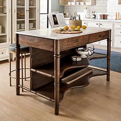 a kitchen island with two stools in front of it and an open shelf on the other side