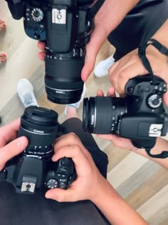 three people holding up their cameras to take pictures with one person's hands and the other