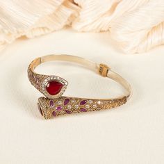 Step into a world of elegance with our Ruby Bangle, where the allure of a red ruby is embraced by the brilliance of delicate diamonds. This exquisite bracelet boasts a radiant red ruby, symbolizing love and passion, meticulously set at the center. Surrounding the ruby, a graceful band of sterling silver encrusted with sparkling diamonds adds an irresistible touch of glamour and finesse ★Our jewelry pieces draw attention to the many aspects of your body. Also, our designs allow you to adopt fresh appearances. ★ Speak volumes about your personality and beliefs with our product. ★ It's excellent for any occasion, whether you're dressed up for a major event or just want to liven up your everyday outfit! ★ Our products are hypoallergenic and completely safe for your skin. We don't use anything Elegant Luxury Red Bangle, Luxury Ruby Bangle As A Gift, Luxury Elegant Ruby Bracelet, Luxury Ruby Bracelets For Wedding, Luxury Ruby Gemstone Bangle, Luxury Ruby Bracelets For Festive Occasions, Elegant Red Bracelet For Gift, Elegant Red Bangle Bracelets, Luxury Red Ruby Jewelry