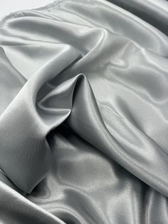 Silver crepe back satin This high-quality satin fabric is a perfect choice for any project that requires a touch of elegance and sophistication. The 58-inch width make it suitable for a wide range of applications, from apparel to home decor and crafts. The fabric comes in a beautiful shade of silver, which adds a classy and luxurious feel to any design. Ideal for use in bridal dresses, blazers, curtains, and even marquees, this shiny crepe back satin fabric offers excellent drape and durability. Whether you are a professional designer or a DIY enthusiast, this fabric is sure to inspire your creativity and help you create stunning and unique creations. Get your hands on this gorgeous fabric today and let your imagination run wild! Delivery All items are dispatched within 1-2 working days. A Wedding Dress Material, Deco Dress, Colour Matching, Back Stretches, Silver Fabric, Luxurious Fabric, Stretch Crepe, Gorgeous Fabrics, Shine On