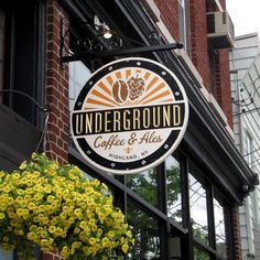 the under ground coffee and ale sign is hanging from the side of a brick building