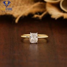 an engagement ring with a cushion cut diamond in the center on top of a wooden table