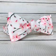 "Pale pink cherry blossoms on white cotton sateen. Because of the handmade nature of these bowties they can vary in size ever so slightly but on average the bow measures 5 inches by 2 inches when tied. hand wash/ spot wash only The self-tied option will be made in the style pictured. The pre-tied option will have the addition of a hook in the back, and the bow will be stitched in the tied position. RETURNS: I accept returns on items in original, unused condition. You will receive a refund for th White Bow Tie For Spring, White Bow Tie For Gifts, White Bow Tie Gift, White Bow Tie For Summer Wedding, Elegant Bow Tie For Spring Gifts, Elegant White Bow Tie For Spring, Elegant Bow For Gift In Spring, Adjustable White Tie With Satin Bow, Spring Wedding Bow