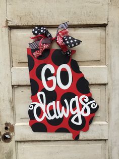 a door hanger with the word go dawgs on it and polka dots