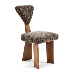 a wooden chair with a fuzzy seat cushion on it's back and legs, in front of a white background