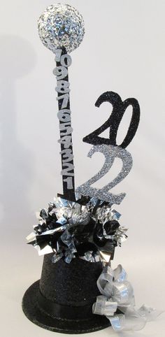 a cake topper that has the number twenty on it and is decorated with silver foil