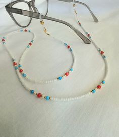 Sunglasses chain Eyeglasses chain Glasses holder This beautiful chain for glasses is made of small white and gold glass beads 2 mm in combination with coral and turquoise beads 3-4 mm. The chain can also be worn as a mask holder if you remove the silicone rubber for the glasses. At the end of the chain is a gold brass clasp in 24 k gold color. If you buy this chain it comes in a beautiful velvet gift bag. We send all shipments by registered mail with a security tracking code. Thank you so much for visiting! FREE SHIPPING! Glasses Necklace Holder, Beads On Sunglasses, Glasses Holder Necklace, Diy Necklace Holder, Chain For Glasses, Eyeglass Chain Holders, Beaded Sunglasses, Eyeglass Chains, Eyeglasses Chain