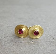 Vintage style gold earrings with tiny red Ruby 14K Gold earrings Yellow gold  Gold dainty earrings Gold stud earrings Everyday earrings Small gold stud earrings with red ruby. This is the perfect everyday earrings, it features a small raw gold disc and a small ruby stone. An excellent choice for anniversary gift or birthday gift for her. ★DETAILS: *Material you can choose: 14k, 9k solid gold. *Red Ruby: 3mm *Disk diameter approx. 8 mm *Butterfly backs included. *Matte finish. ★All my products are handmade and designed by me. *All jewelry comes in a nice package and ready to give as gift. *For any questions, custom order & special requests, please feel free to contact with me. For more earrings: https://www.etsy.com/shop/Arju?ref=seller-platform-mcnav§ion_id=7959855 Gold Ruby Earrings With Stone Setting, Ruby Earrings Studs Gold, Ruby Earrings In Yellow Gold For Gift, Gold Earrings With Ruby Birthstone, Ruby Studs Gold, Yellow Gold Ruby Earrings For Gift, Gold Ruby Earrings With Birthstone, Dainty Red 14k Gold Earrings, Ruby Yellow Gold Earrings For Gift