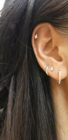 a close up of a person's ear with two piercings