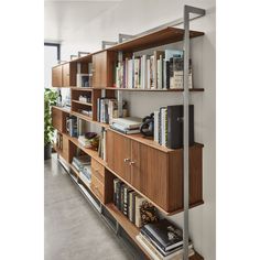 a bookshelf filled with lots of books next to a wall mounted book shelf