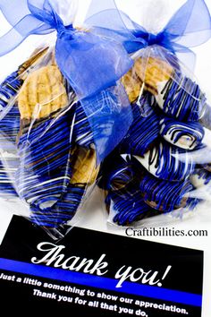 a thank you bag with cookies wrapped in blue ribbon