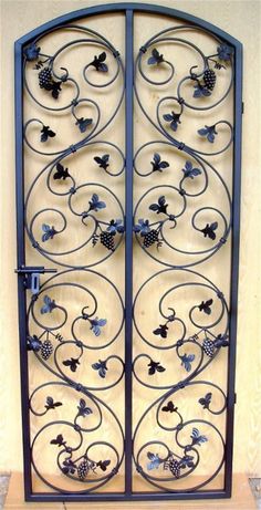 an iron gate with grapes and vines on it