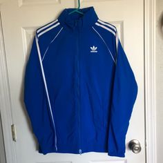 New. Size Small. Hood Can Be Unzipped Or Tucked In Collar. Adidas Original Blue With 3 Stripes On Sleeves Adidas Blue Spring Windbreaker, Blue Adidas Windbreaker For Sports, Blue Adidas Sports Windbreaker, Adidas Sst, Adidas Hooded Moisture-wicking Windbreaker, Black Jacket Hoodie, Retro Windbreaker, Blue Long-sleeved Sports Windbreaker, Adidas Originals Jacket