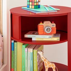 a toy giraffe is on top of a book shelf