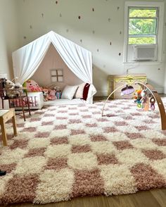 a child's bedroom with pink and white rugs on the floor, furniture and decor