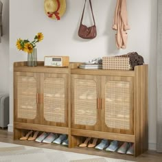 a wooden cabinet with baskets and shoes on it next to a wall mounted coat rack