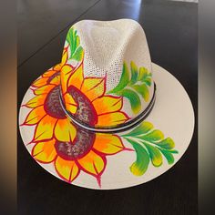 a white hat with sunflowers painted on it