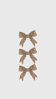 three bows on top of each other in brown and white leopard print, against a gray background