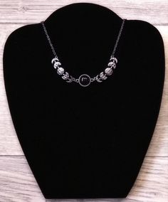 Bring some cosmic magic to your jewelry collection with this Crescent Moon Phase Goddess Choker! This stunning necklace celebrates femininity, intuition, and transformation with its intricate moon phase design. Wear it as a reminder to embrace your inner goddess and radiate positive energy wherever you go. (P.S. It makes a great gift for any moon-loving gal pal!) Chain: 19.7 inches Black Metal Jewelry With Moon Charm, Black Symbolic Jewelry With Adjustable Chain, Symbolic Black Jewelry With Adjustable Chain, Celestial Black Metal Jewelry, Metal Moon Phase Choker Necklace, Black Metal Moon Shaped Jewelry, Black Metal Moon-shaped Jewelry, Symbolic Metal Necklace With Moon Phase Detail, Symbolic Black Necklace With Adjustable Chain