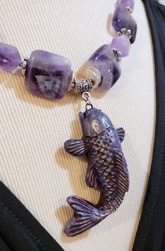 Gorgeous handmade polymer clay purple Koi Fish pendant made by Massachusetts artist Stacey. I gave this purple Koi Fish a necklace of genuine Amethyst beads, (squares and irregular chunks), purple colored freshwater pearls, 2 light Amethyst ovals (near clasp), tiny purple Swarovski crystal bicone beads and pewter spacers and toggle clasp, (cadmium and lead free). This necklace is 20 inches long and the Koi pendant drops down from the necklace approx. 2.5 inches. One Of A Kind I can send it gift Handmade Purple Rectangular Necklace, Rectangular Purple Amethyst Necklaces, Purple Rectangular Amethyst Necklaces, Purple Rectangular Amethyst Necklace, Polymer Clay Koi Fish, Clay Koi Fish, Purple Koi Fish, Fish Necklace, Fish Pendant