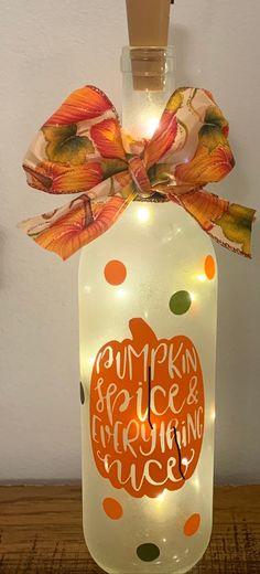 a lighted pumpkin jar with an orange and green polka dot ribbon