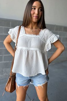 White Ruffle Raw Hem Peplum Top | Lillian Top - White – Mindy Mae's Market Summer Ruffle Top With Flutter Sleeves, Summer Tops With Ruffles And Flutter Sleeves, Casual Cotton Flutter Sleeve Tops, Casual Cotton Tops With Flutter Sleeves, Summer Tops With Flutter Sleeve And Ruffle Hem, Chic Summer Tops With Flutter Sleeves, Flutter Sleeve Tops With Ruffle Hem For Vacation, Billowy Cotton Top For Day Out, Relaxed Fit Cotton Top With Ruffle Sleeves